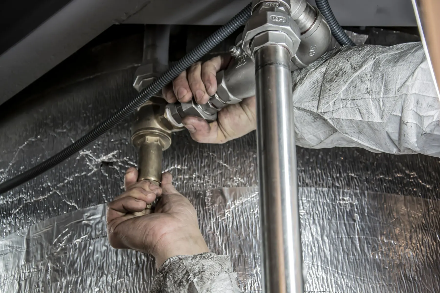 Klempner arbeitet an Wasserrohren